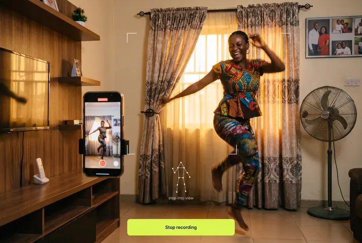 An afrobeats dancer in Lagos at golden hour, a propped phone running the app. AI-generated scene · real app screen